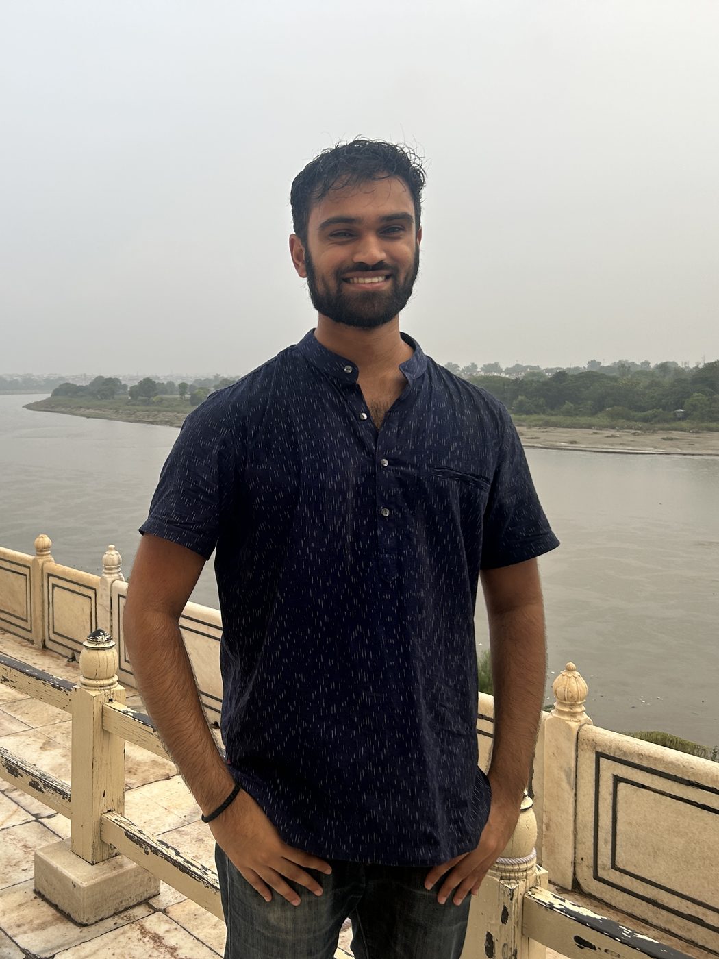 Prithvi standing on a stone terrace above a wide river