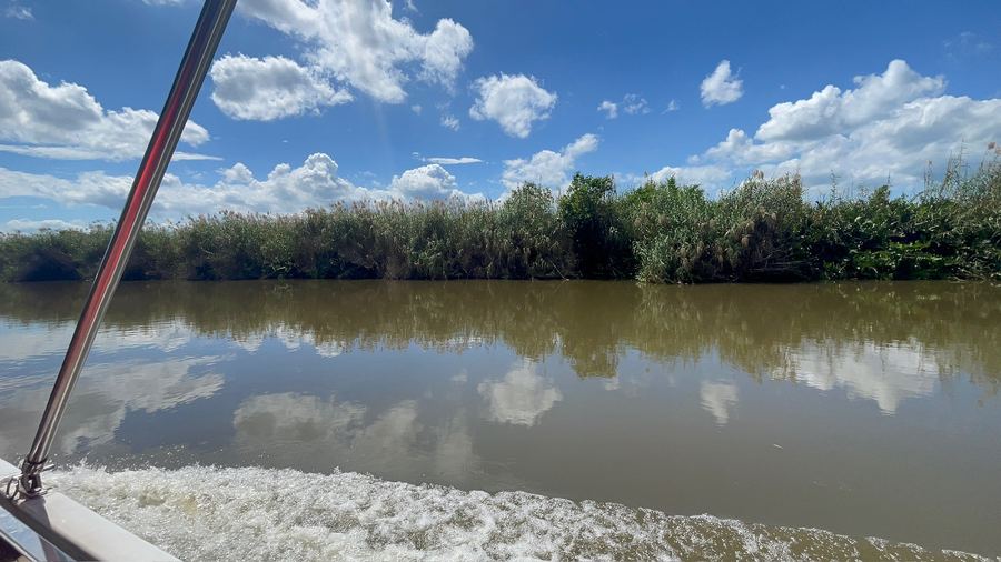 Clouds reflected on a still, wide river